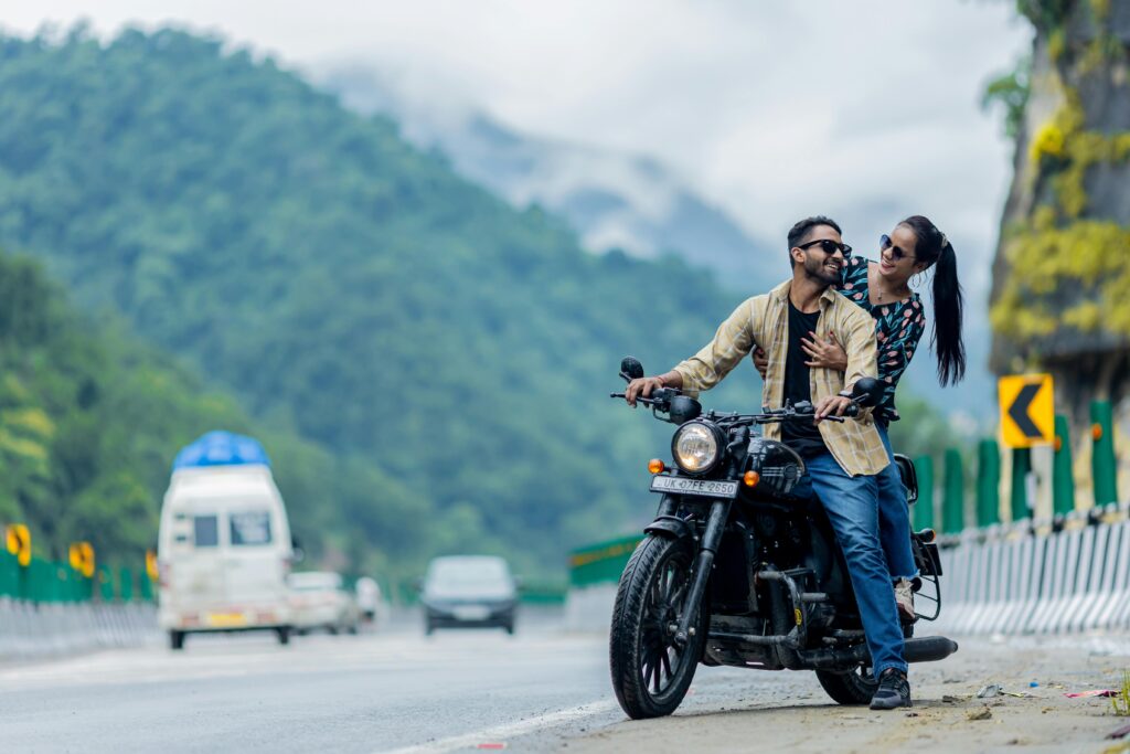 Couple enjoying a romantic bike ride amidst scenic mountains in Rishikesh.