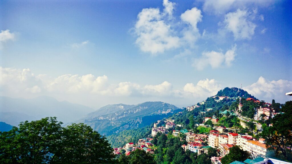 Picturesque view of Shimla's mountains and townscape under a clear blue sky.