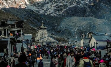Crowd at Kedarnath Temple, India with stunning Himalayan backdrop, a top travel destination.