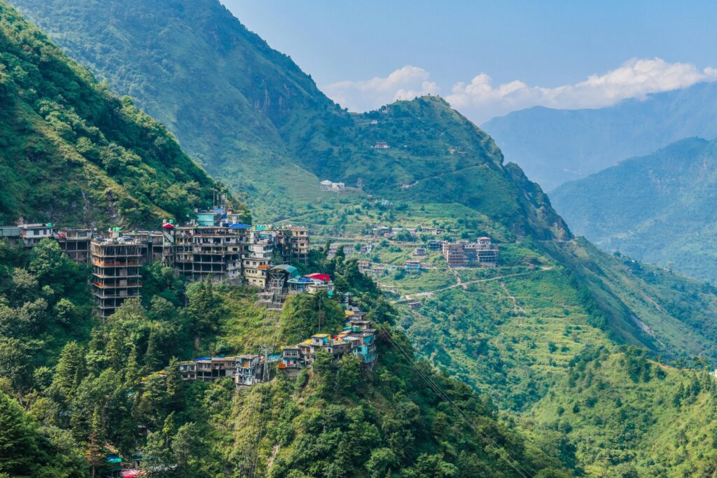 Explore the stunning aerial view of Rishikesh with its lush green mountains and vibrant town nestled in nature.