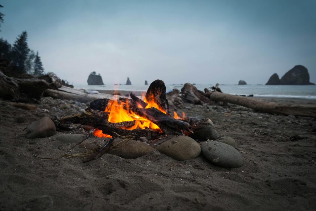 Warm campfire on a rocky beach along the Olympic Coast, perfect for a relaxing evening.