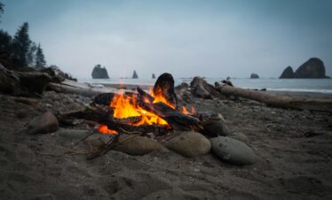 Warm campfire on a rocky beach along the Olympic Coast, perfect for a relaxing evening.