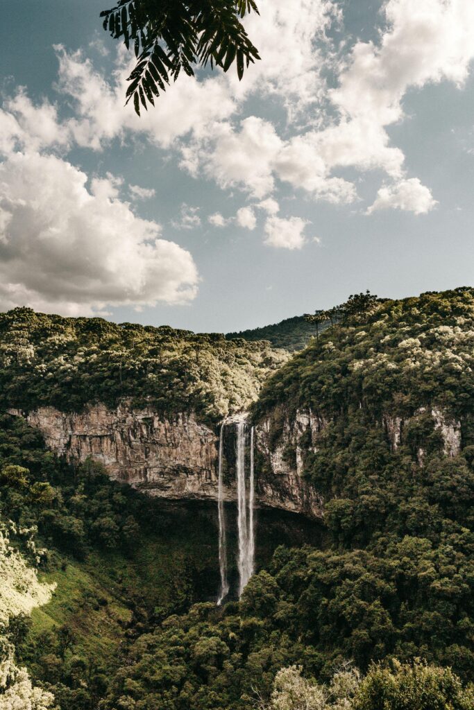 Explore the majestic Caracol Falls set amid dense Brazilian forests under a cloudy sky.