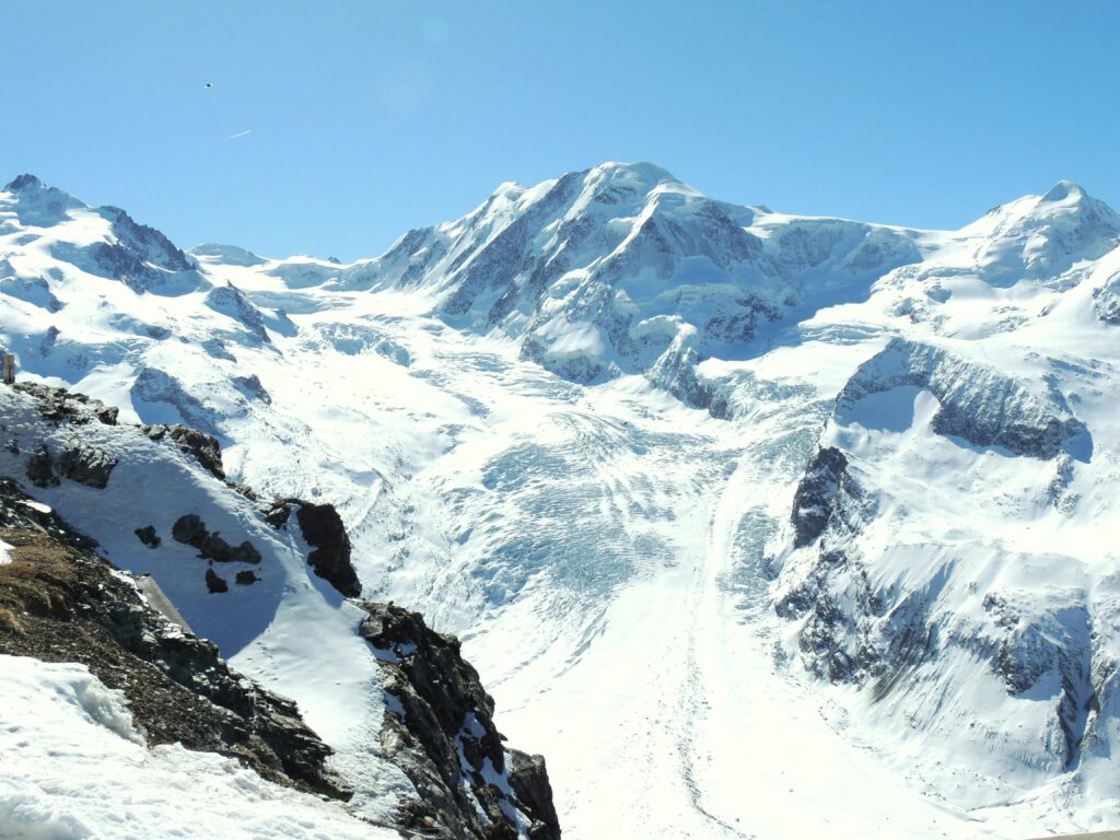 Stunning snow-covered mountain peaks of the Swiss Alps in Zermatt, Switzerland, under a clear blue sky.