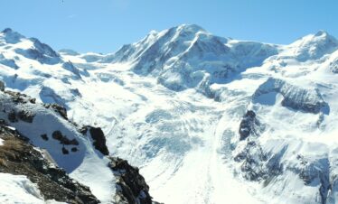 Stunning snow-covered mountain peaks of the Swiss Alps in Zermatt, Switzerland, under a clear blue sky.