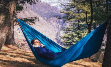 A man relaxes in a hammock amidst the scenic beauty of Tosh, Himachal Pradesh, India.