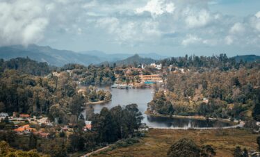 A beautiful aerial shot of Kodaikanal's lush landscape and serene lake surrounded by mountains.