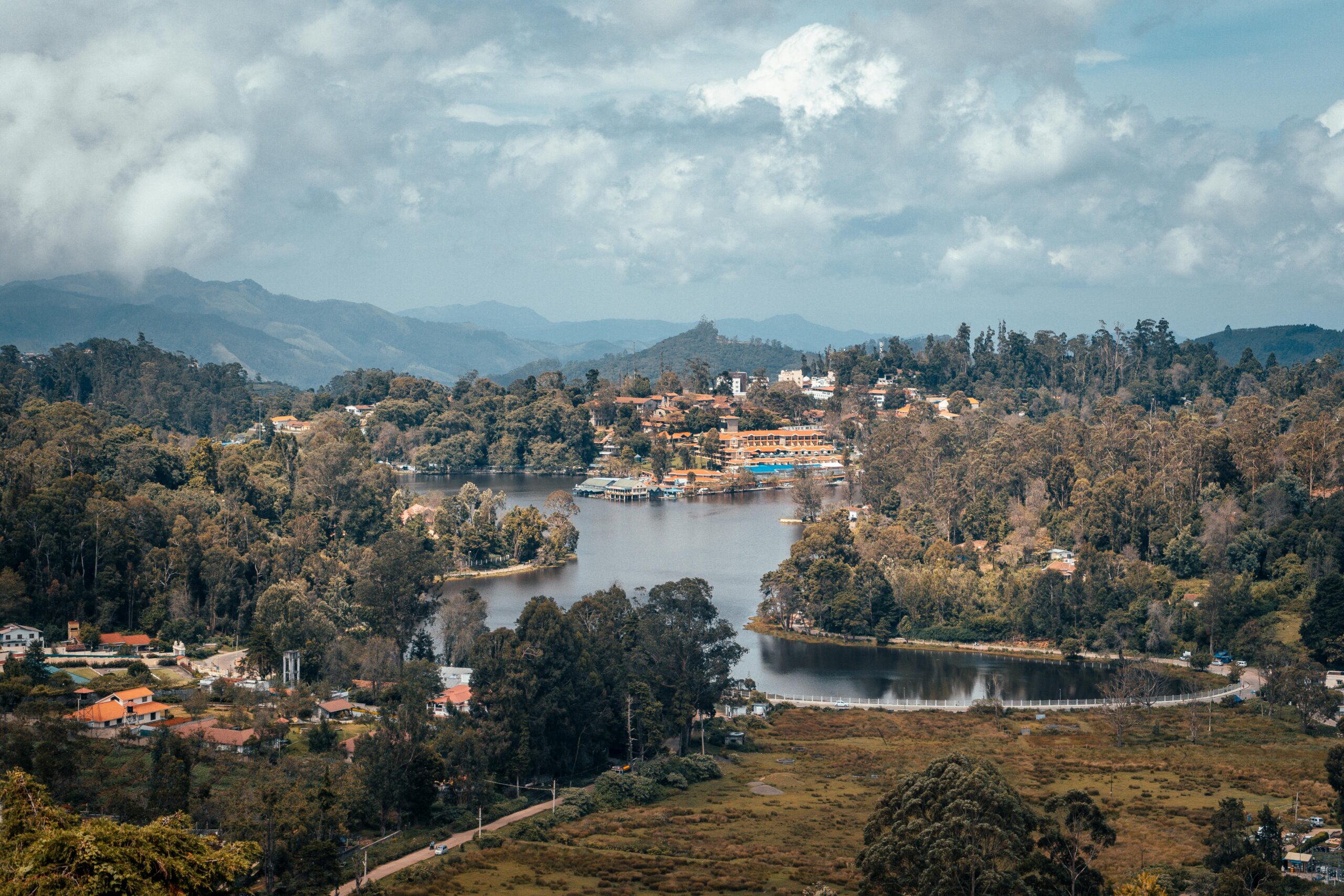 A beautiful aerial shot of Kodaikanal's lush landscape and serene lake surrounded by mountains.